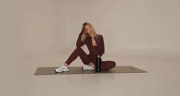 Fitness modelka v elegantním sportovním setu během relaxace po tréninku