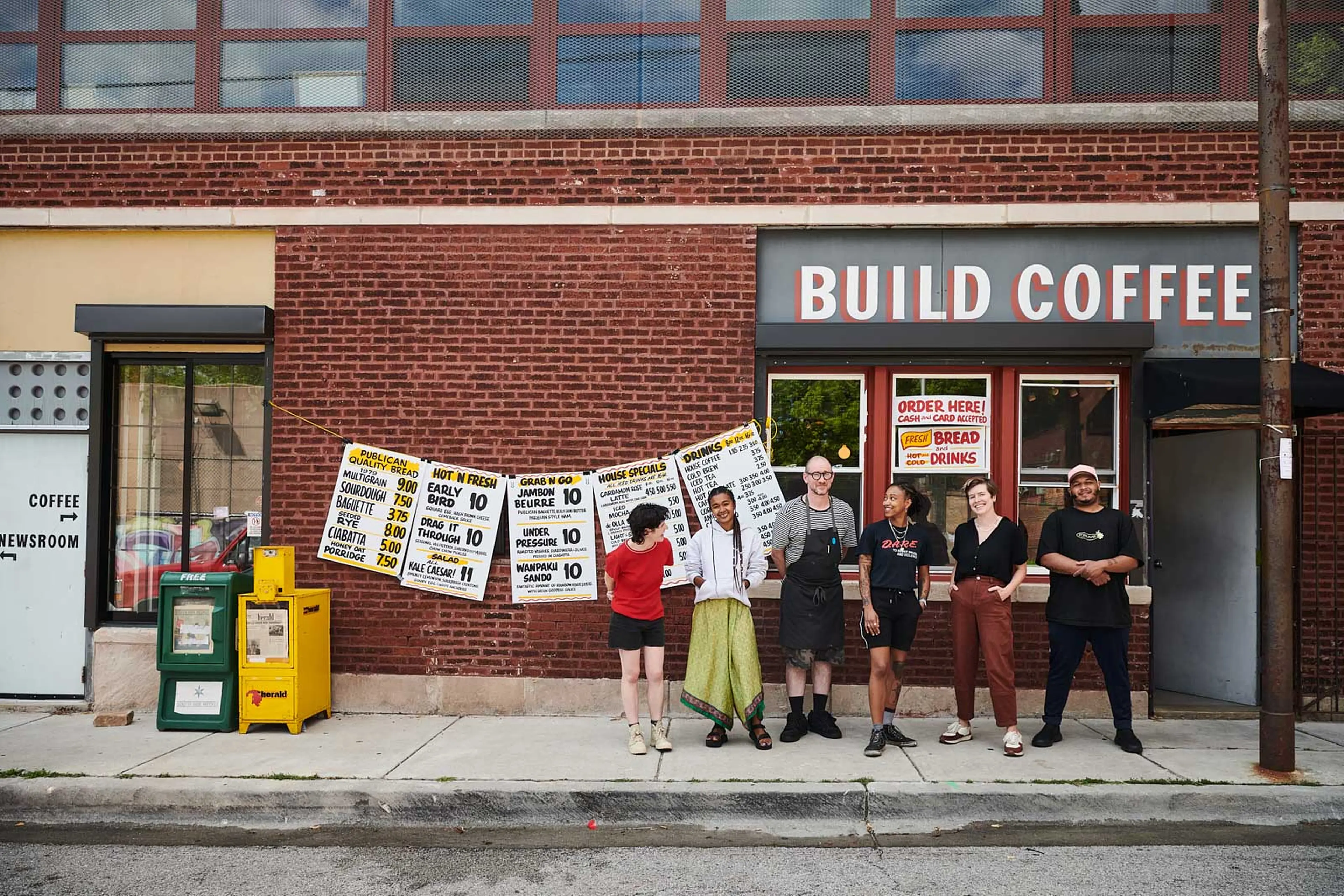 Happy people standing in front of a coffee shop