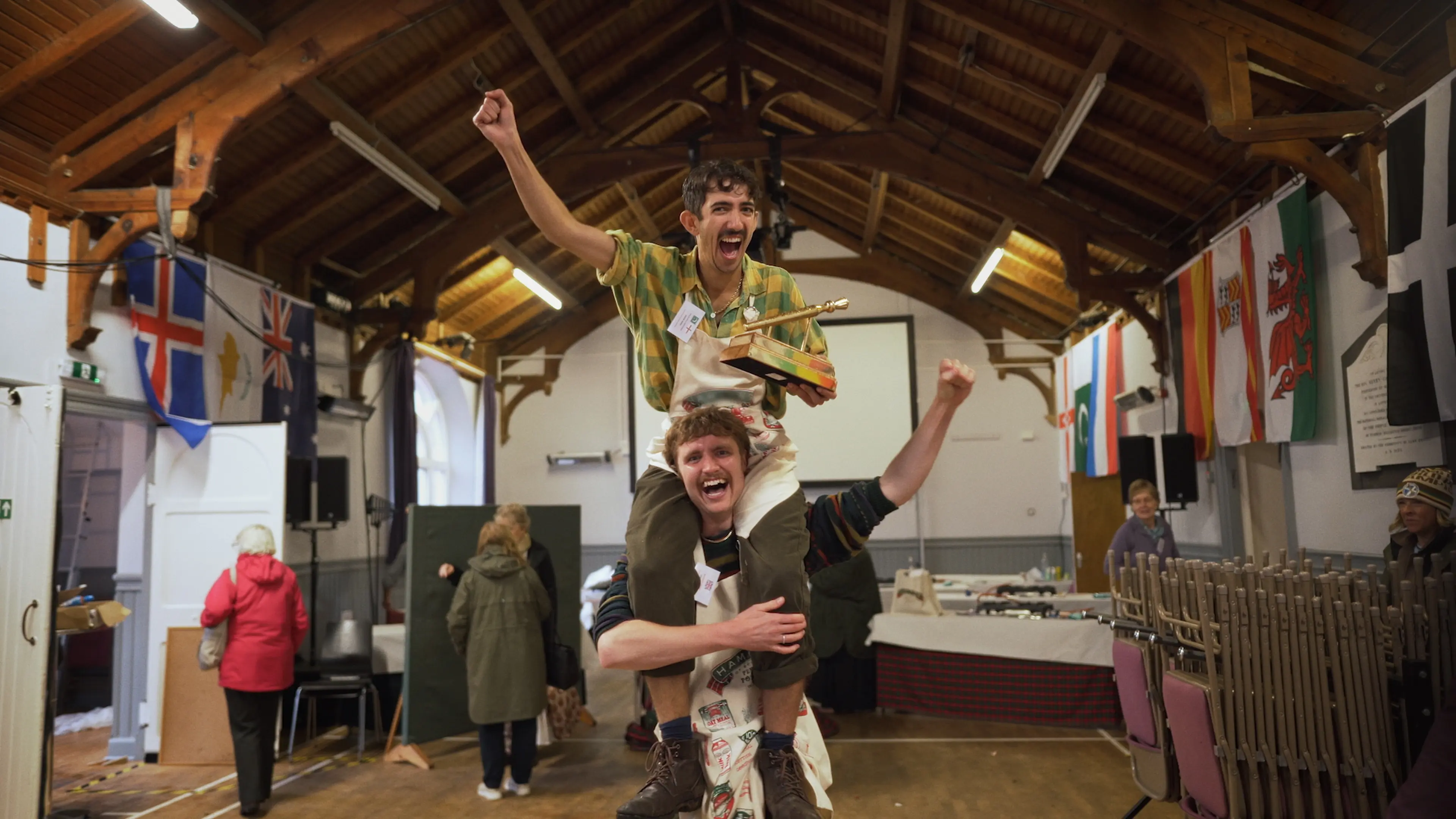 The winner of the Golden Spurtle, Adam, is sitting on his friend's shoulders.