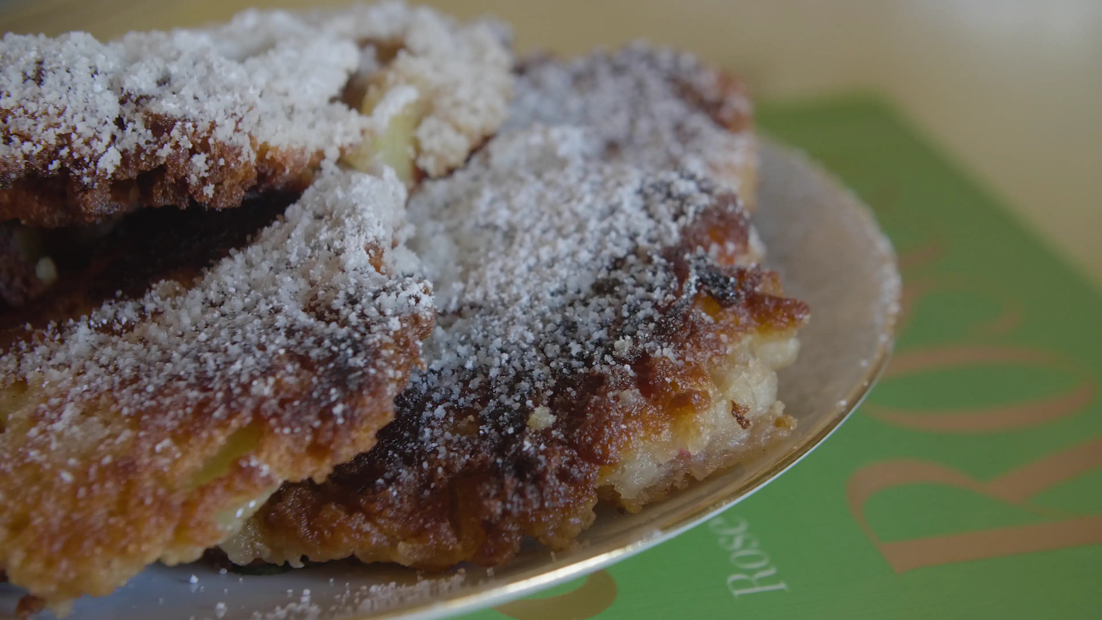 A close-up of sugary cream cheese apple fritters.