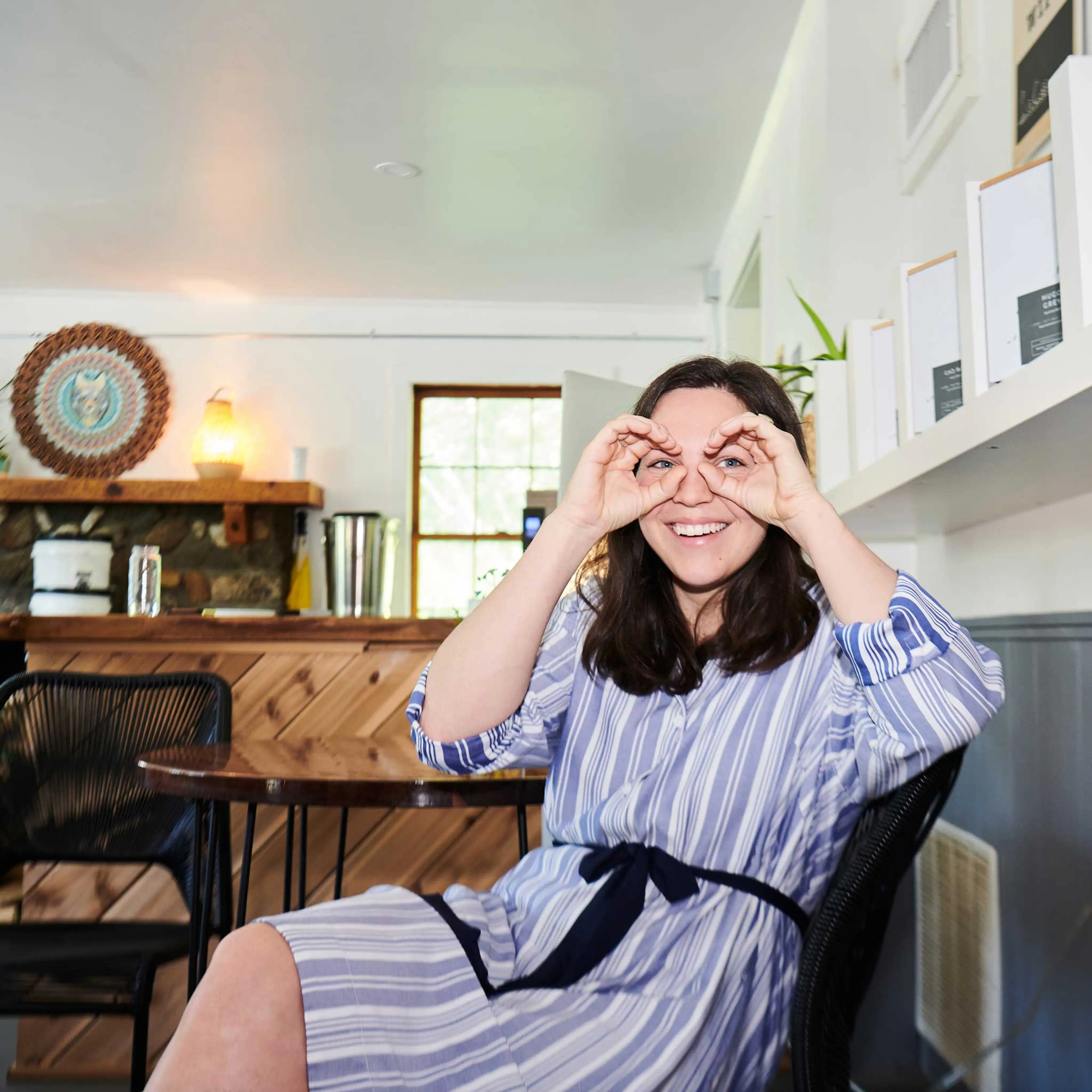Woman sitting and forming glasses with her hands