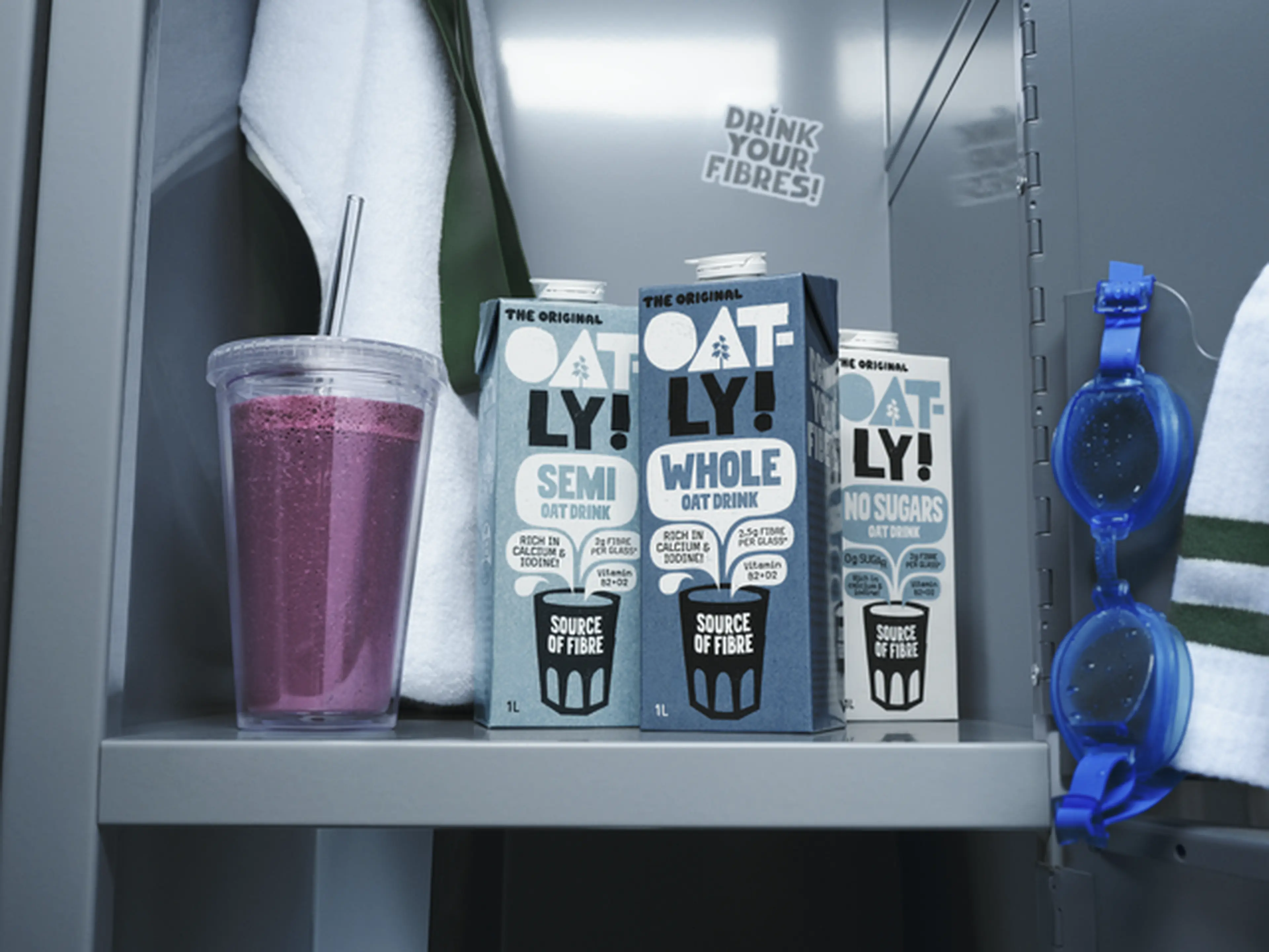 A smoothie, swim googles and three Oatly oat drinks in a locker.