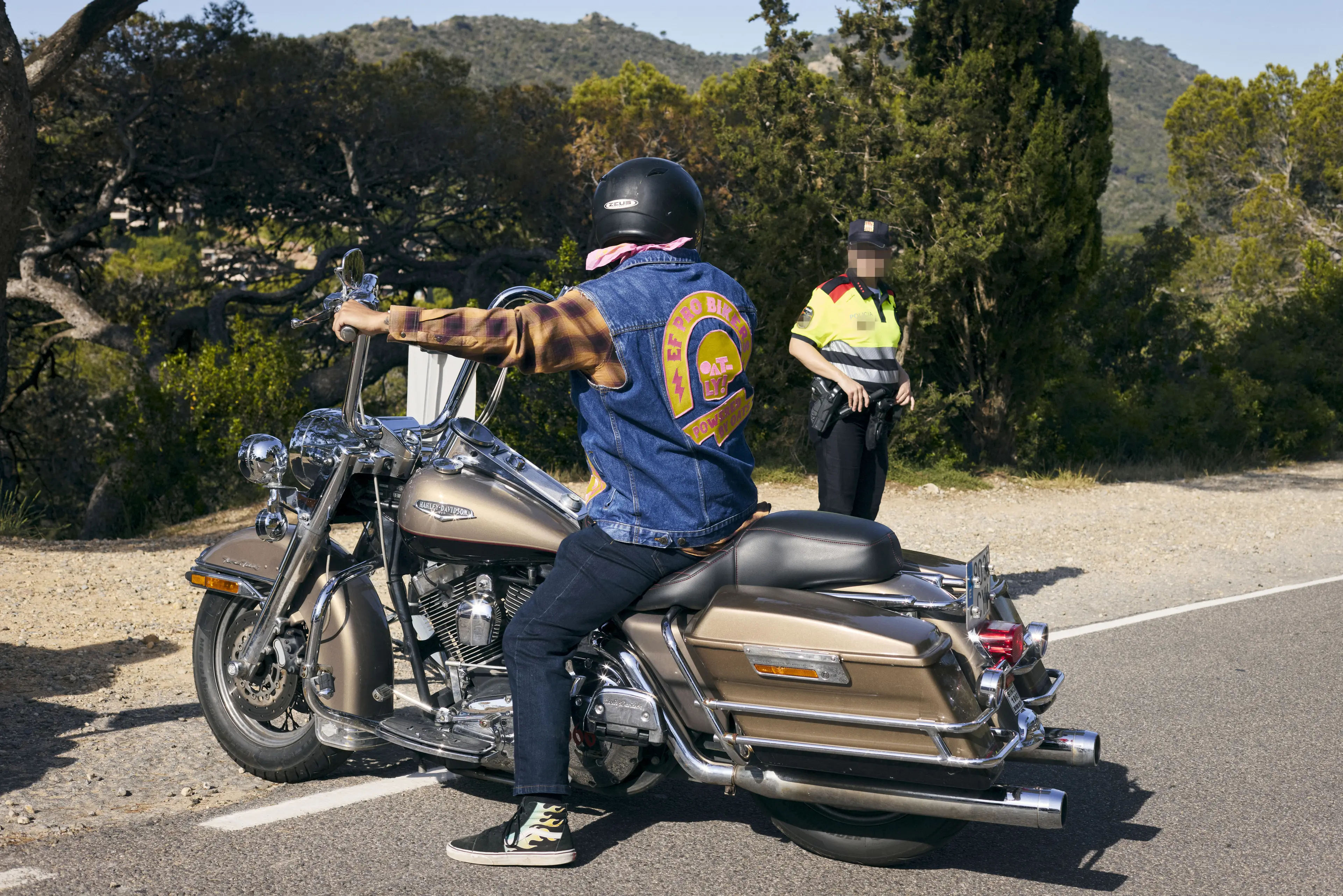 EF Pro Biker on a motorcycle standing on the side of a road with a police officer in the background