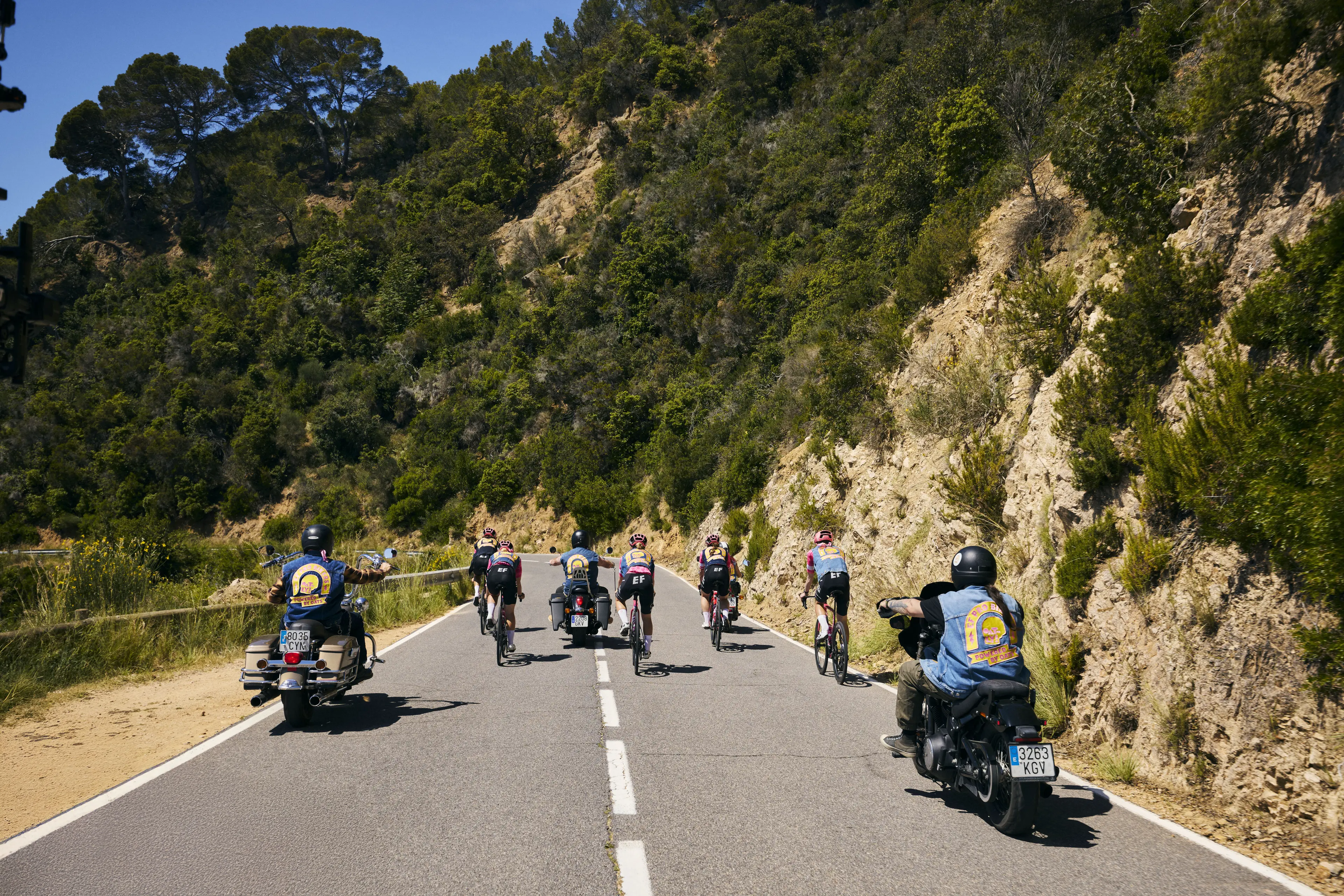 EF Pro Bikers riding away along a winding road