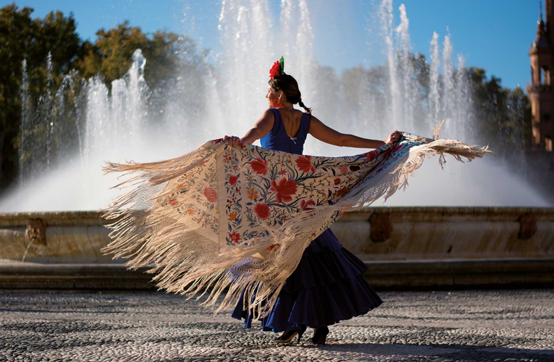 Beautiful woman dancing flamenco near the fountain