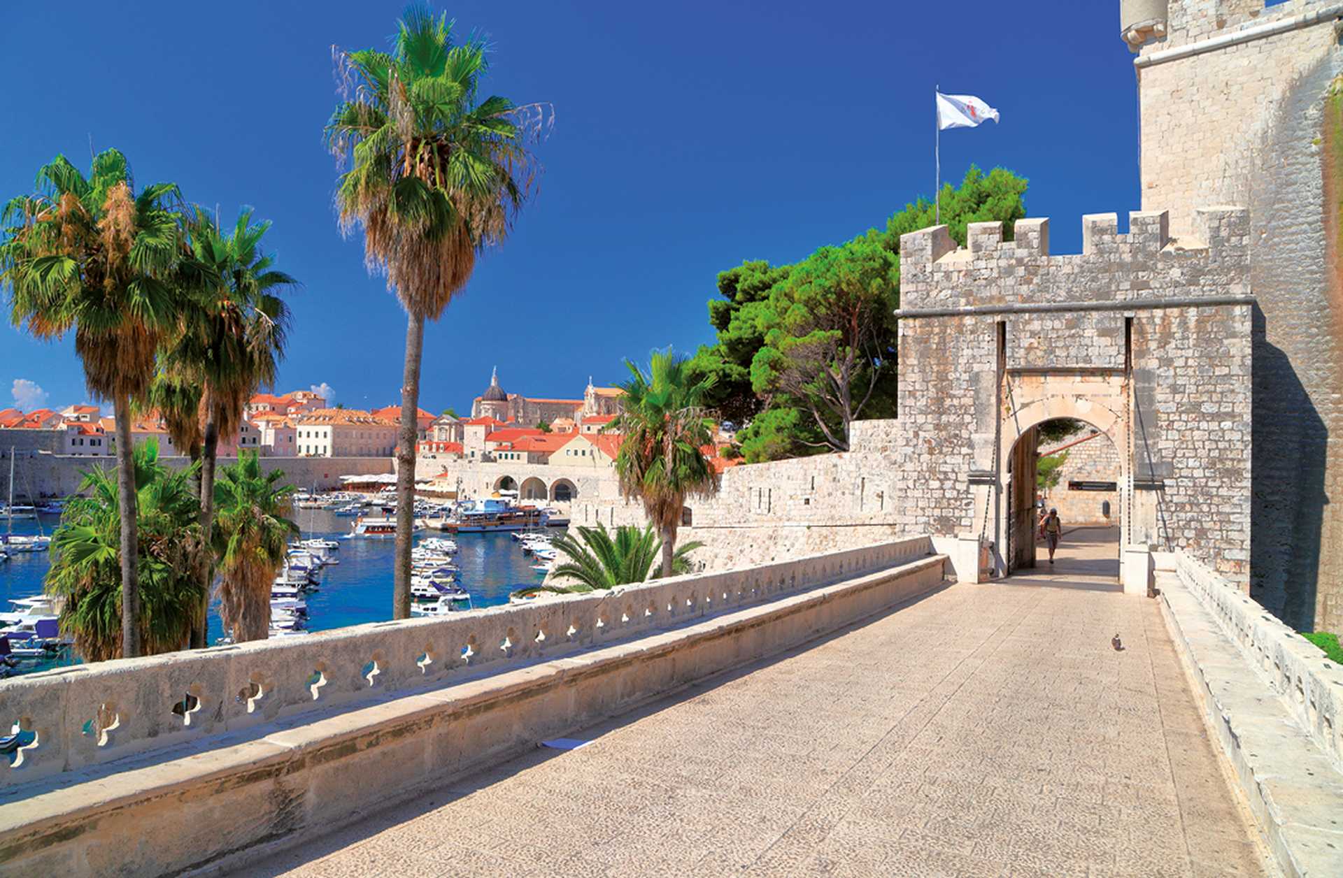 Long bridge to the sunny gate leading tourists inside old town of Dubrovnik, Croatia