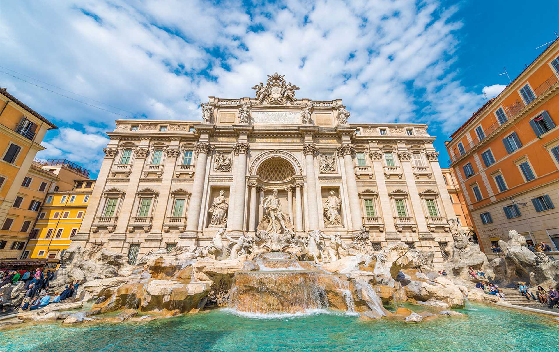Trevi fountain in a sunny day with blue sky and clouds in Rome.