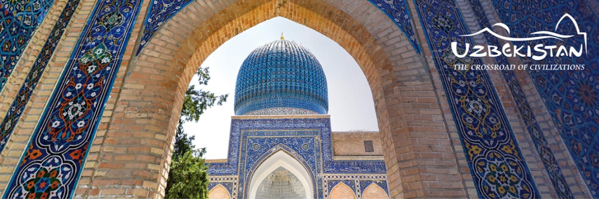 A panoramic view through an Uzbekistan building archway with the tourist board logo top right-hand corner