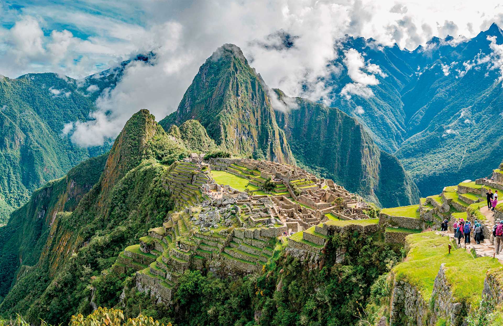 Panoramic view of Machu Picchu on sunny day with clouds