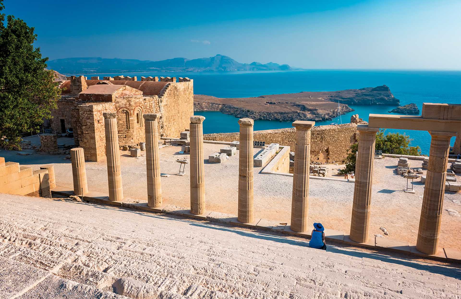 Woman sitting on Staircase of the Propylaea on the Acropolis of Lindos (Rhodes, Greece)