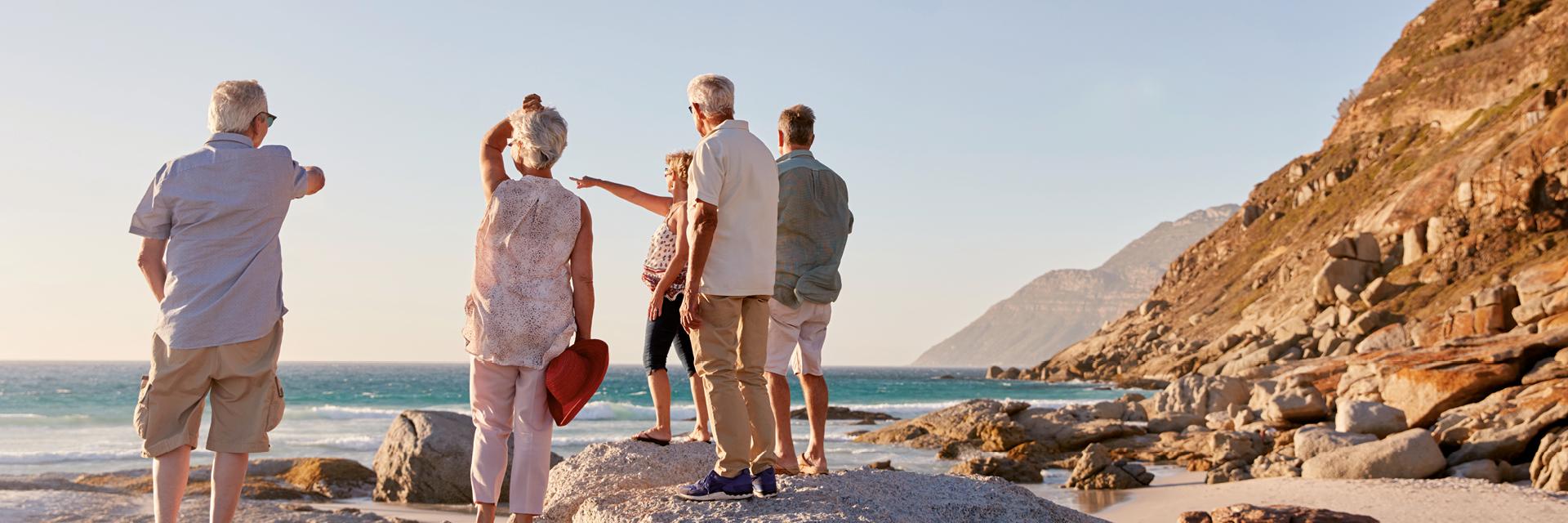 Rear View Of Senior Friends Standing On Rocks, beach