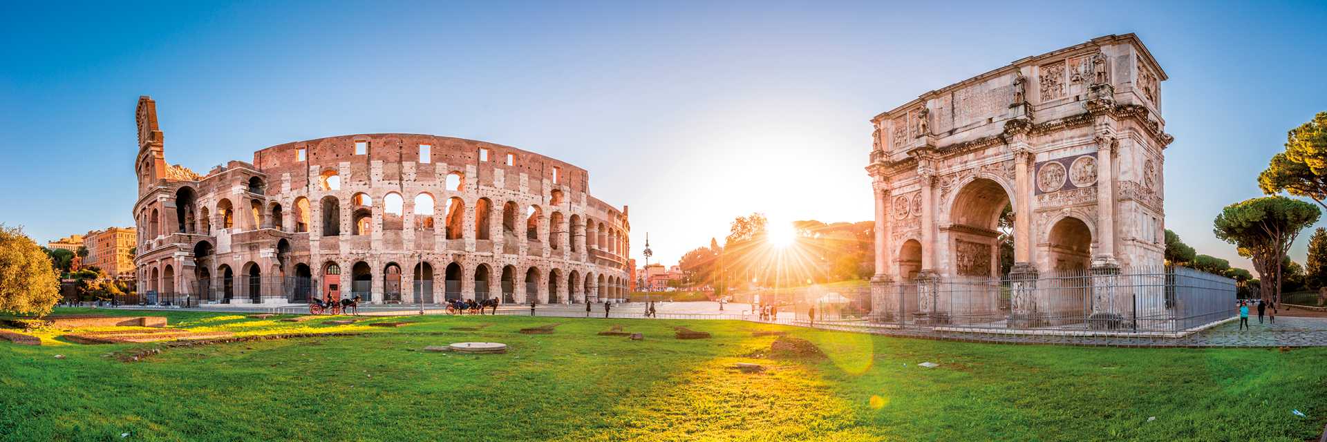Panorama of Colosseum and Constantine arch at sunrise in Rome. 