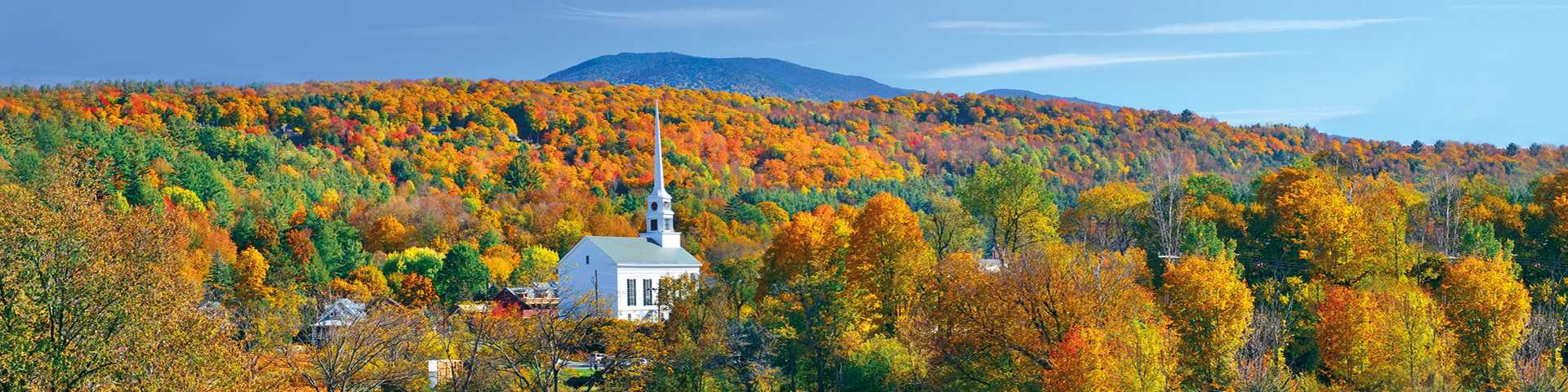 Stowe panorama in Autumn with colorful foliage and community church in Vermont