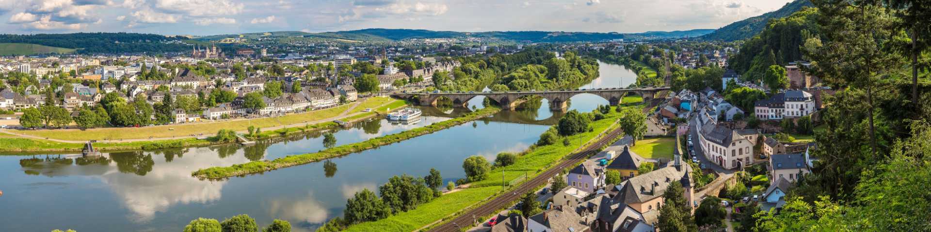 trier,  country,  german,  moselle,  city,  church,  germany,  panoramic,  ship,  tourism,  aerial,  mosel,  scenic,  house,  building,  vineyard,  view,  rhineland-palatinate,  above,  cityscape,  day,  europe,  sky,  roof,  famous,  nature,  old,  european,  history,  water,  boat,  coast,  hill,  sinuosity,  panorama,  blue,  treves,  cruise,  valley,  bridge,  river,  travel,  landscape 
