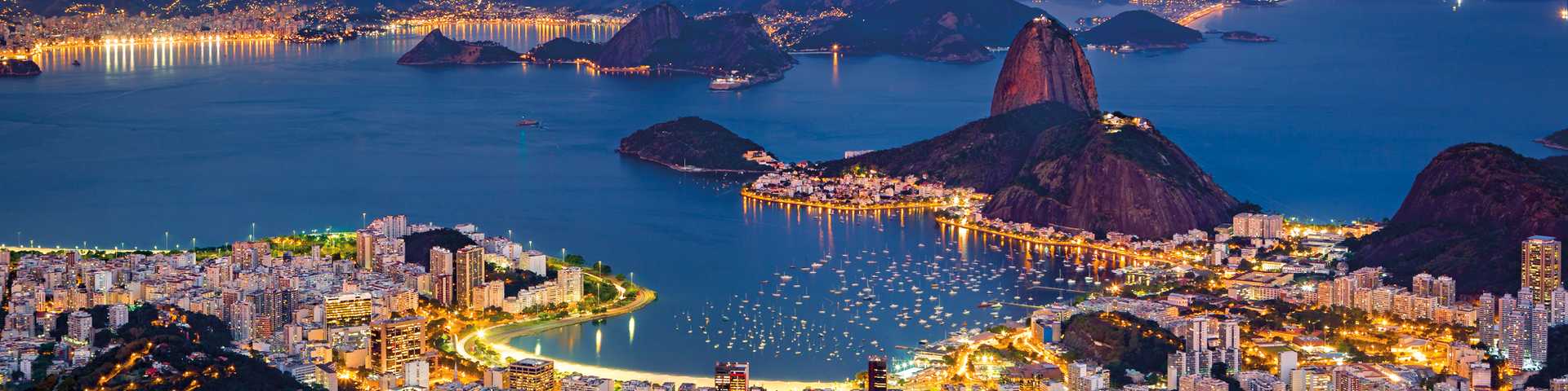 View over city of Rio de Janeiro at night with city lights and Sugar loaf mountain, Brazil