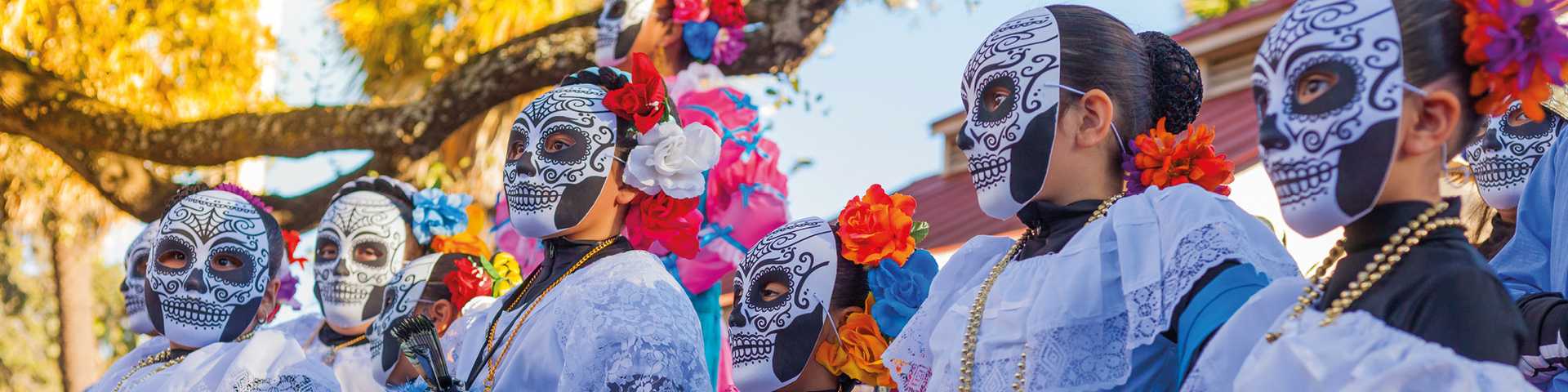 Group of women wearing traditional sugar skull masks and costumes for Dia de los Muertos celebration, Mexico 
