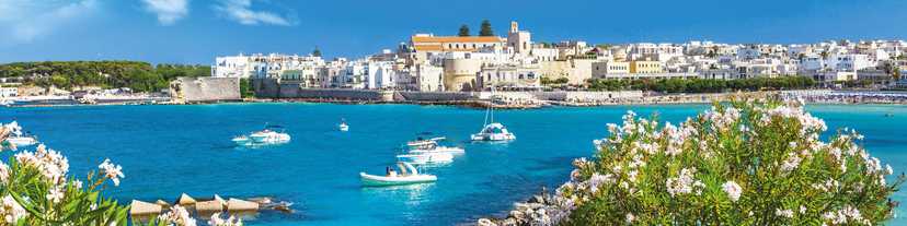 Turquoise waters of the sea with white-washed buildings of Otranto, Puglia, Italy