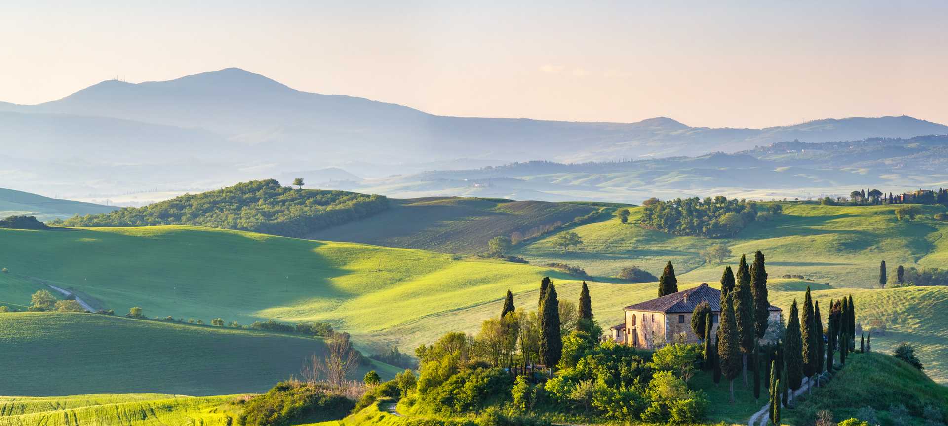 A villa sits on a hilltop surrounded by Tuscan countryside 