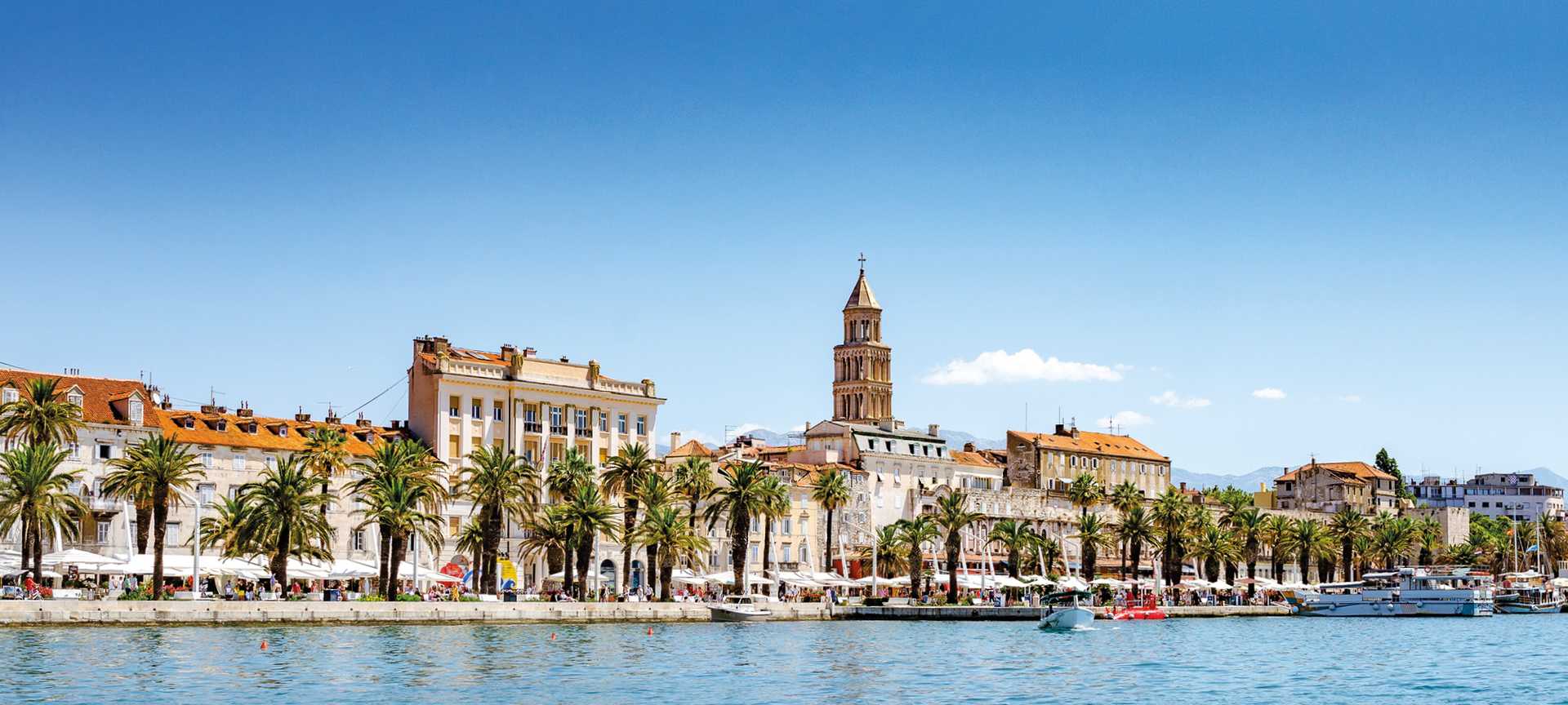 View from the water looking back at Split's palm-lined promenade and Diocletian's Palace, Croatia