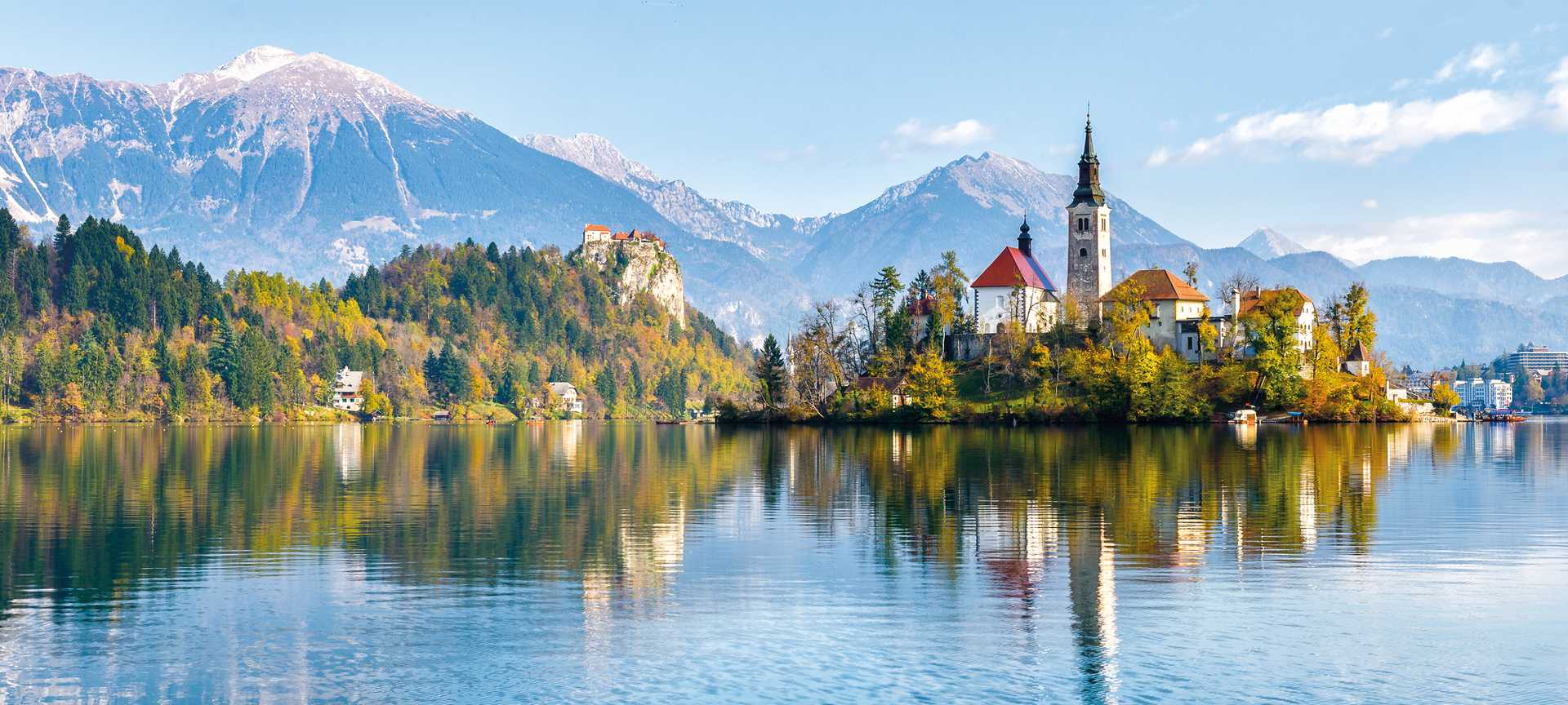 View across Lake Bled to Bled Island, with the Pilgrimage Church of the Assumption of Maria and Bled Castle in the background