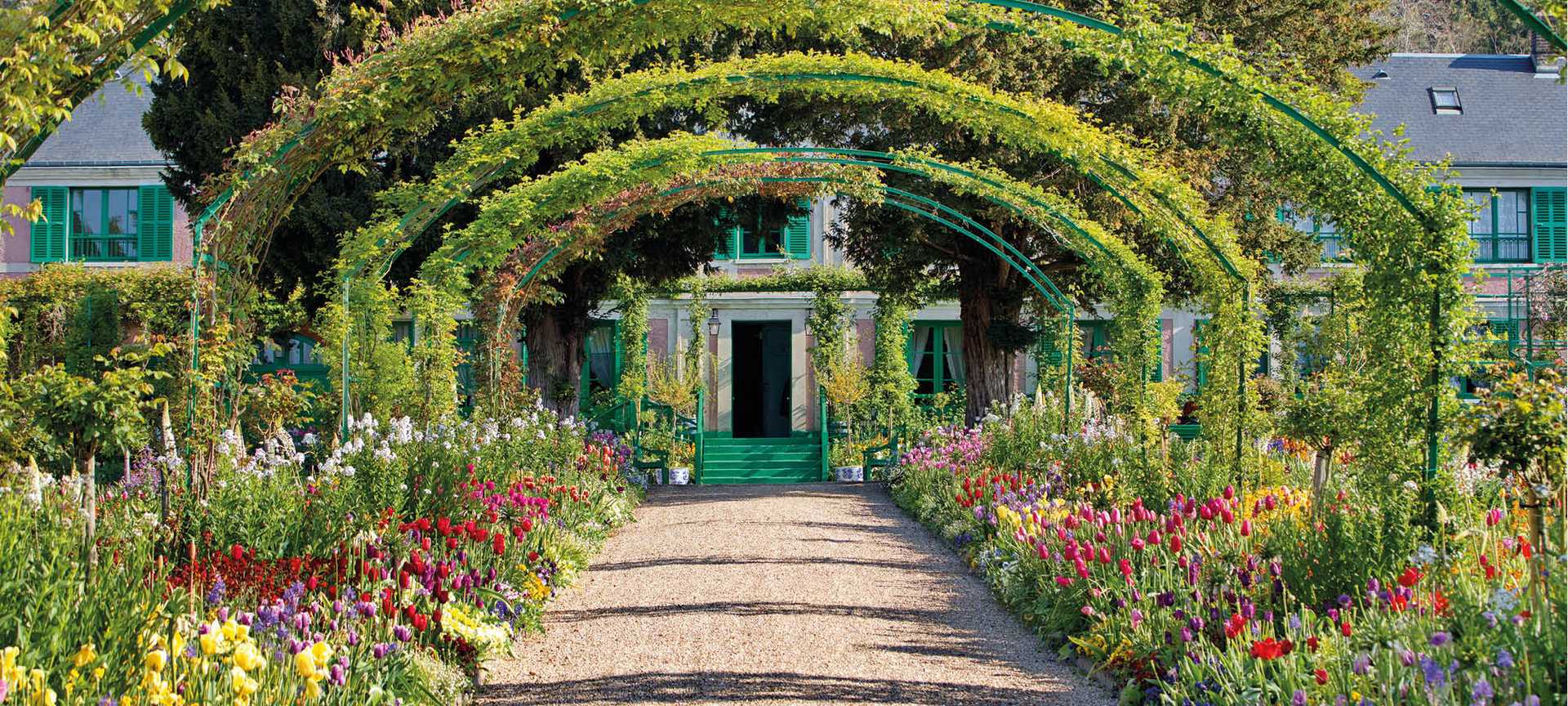 Beautiful flowers line a walkway leading to Monet's house and garden in Giverny, France