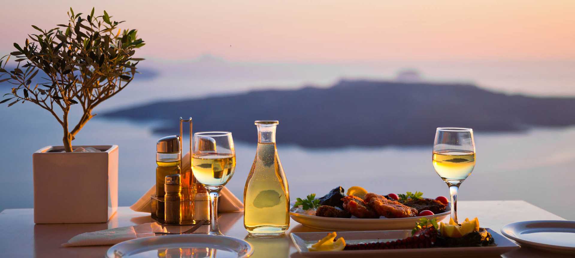 Dinner for two with wine is served at a table overlooking the caldera in Santorini, Greece