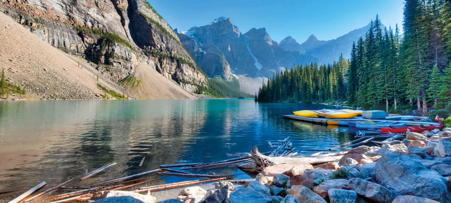 Colorful canoes and reflecting waters of Moraine Lake in Banff National Park Alberta Canada