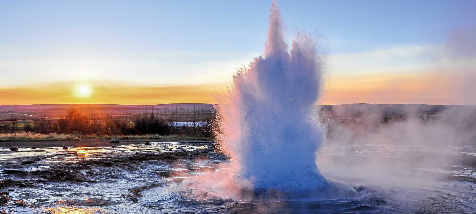 Geyser erupting at sunrise, Iceland