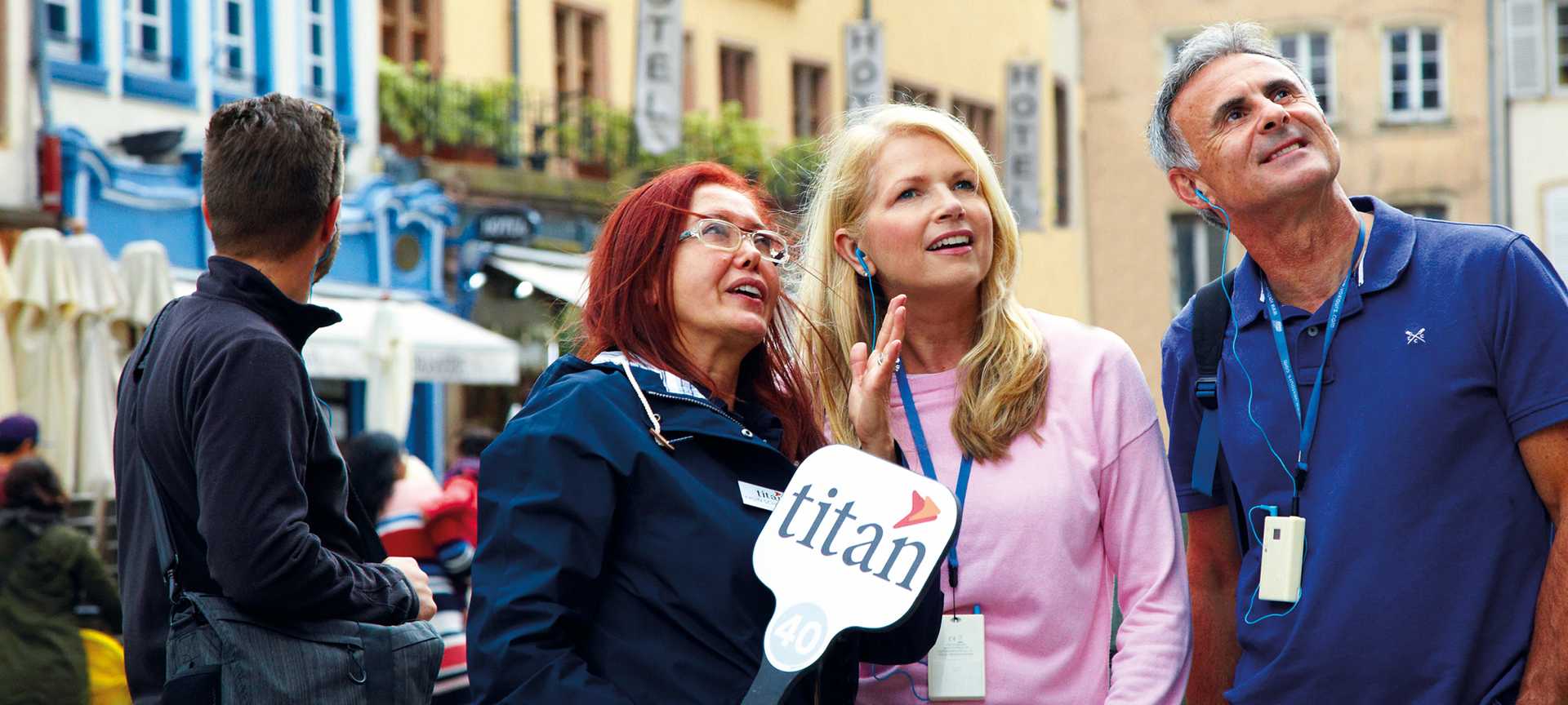 A Titan tour manager talking to two customers