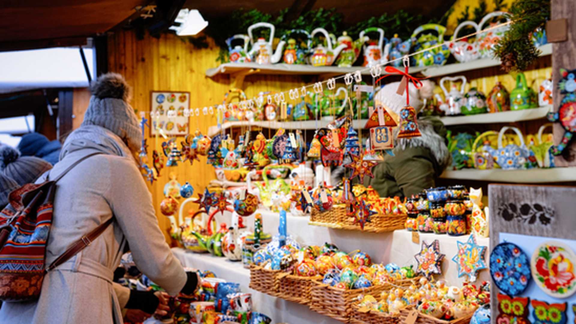 Woman and Wooden Christmas tree decorations at Christmas market in Germany in Europe in winter. German Night street Xmas and holiday fair in European city or town, December. Gendarmenmarkt in Berlin