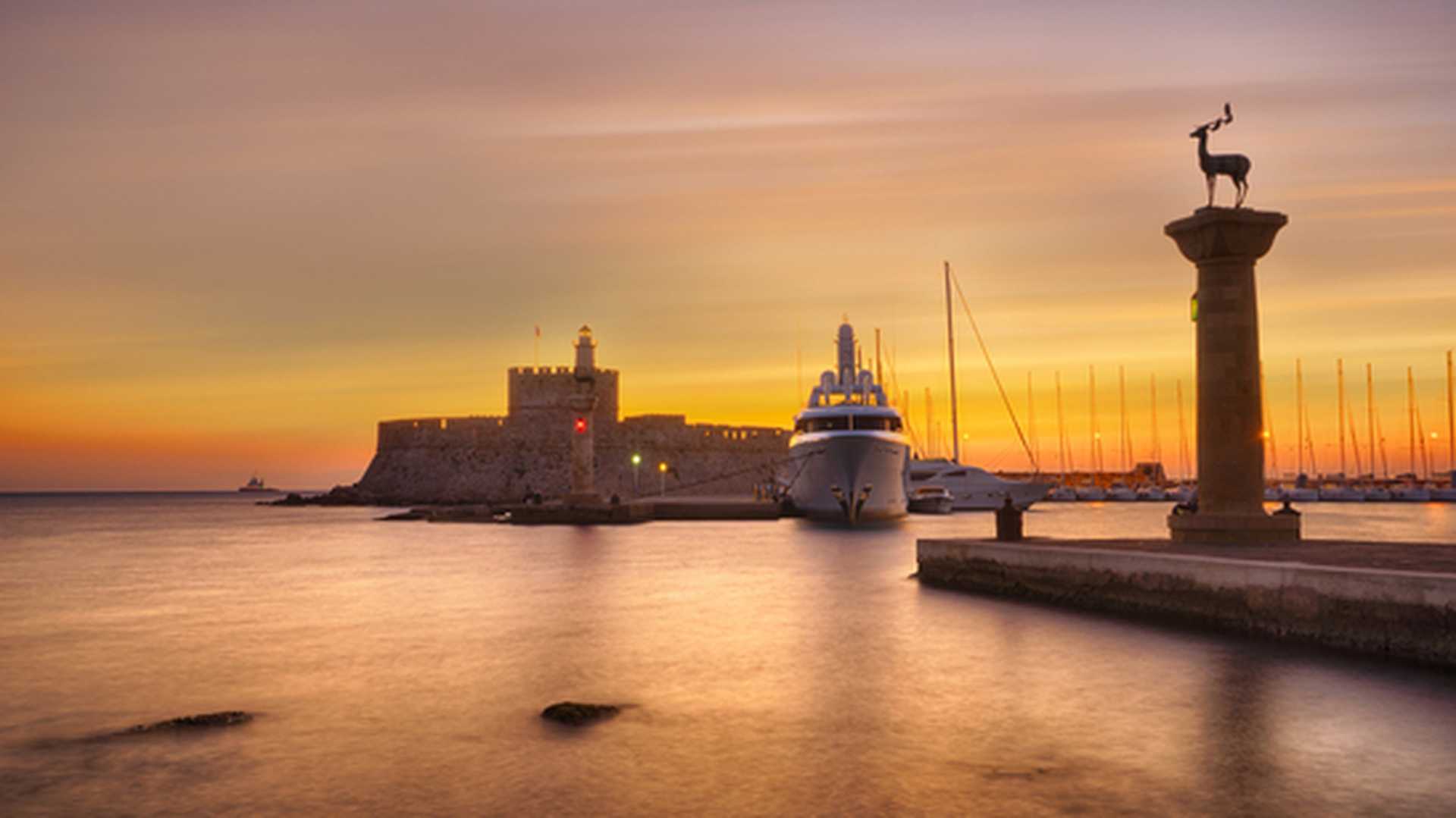 Agios Nikolaos fortress on the Mandraki harbour of Rhodes Greece at dusk