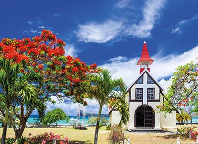 Red church on the beach with blooming flamboyant tree, Cap Malheureux, Mauritius