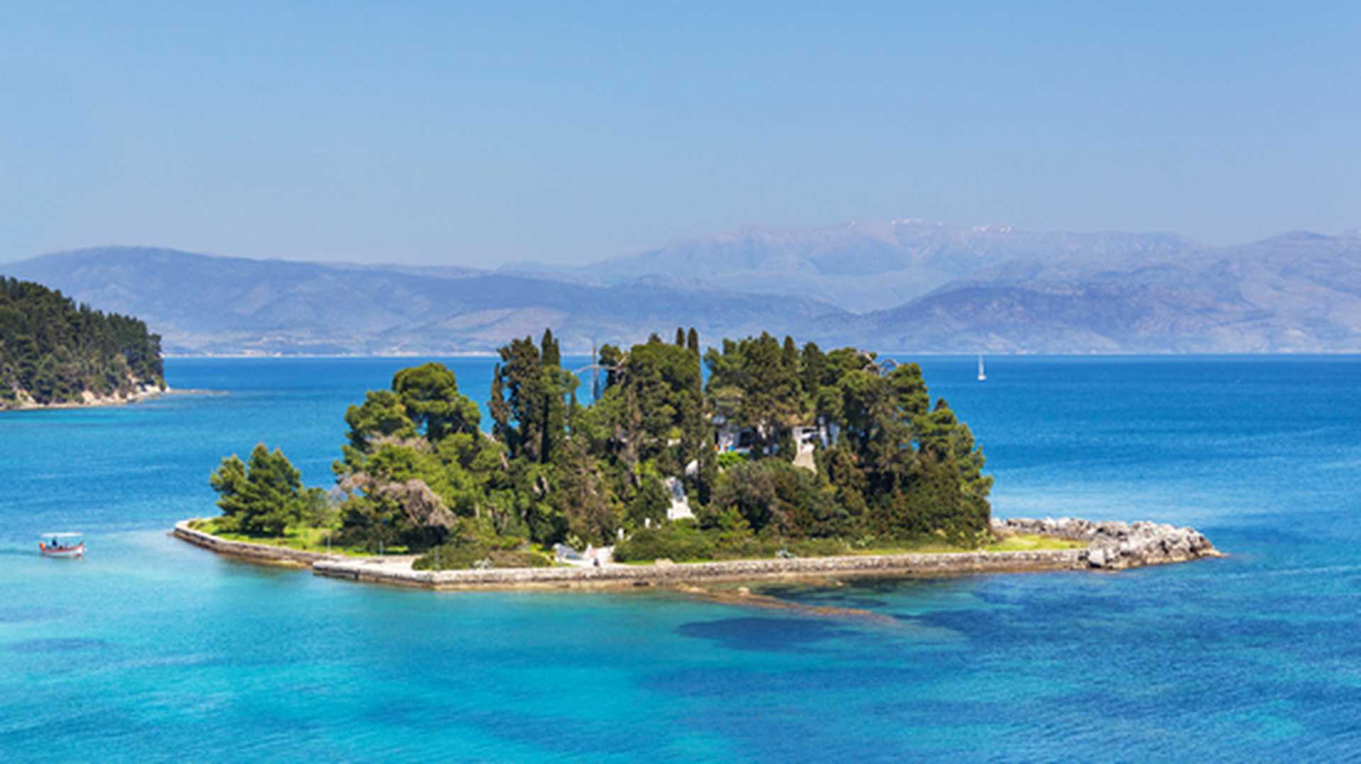 View across to tiny Mouse Island, Corfu, with the mountains of the Greek mainland in the background