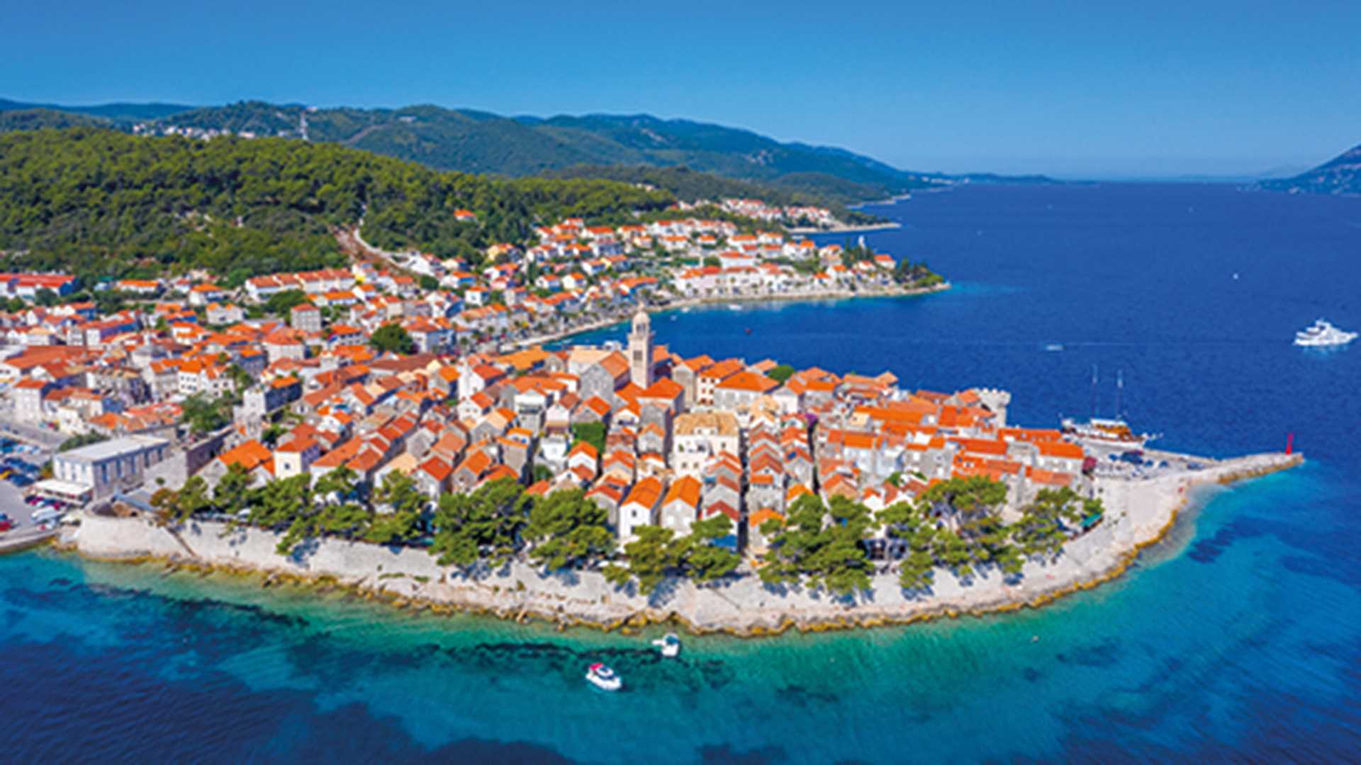 View over bright blue sea and orange roofed houses of Korcula, Croatia