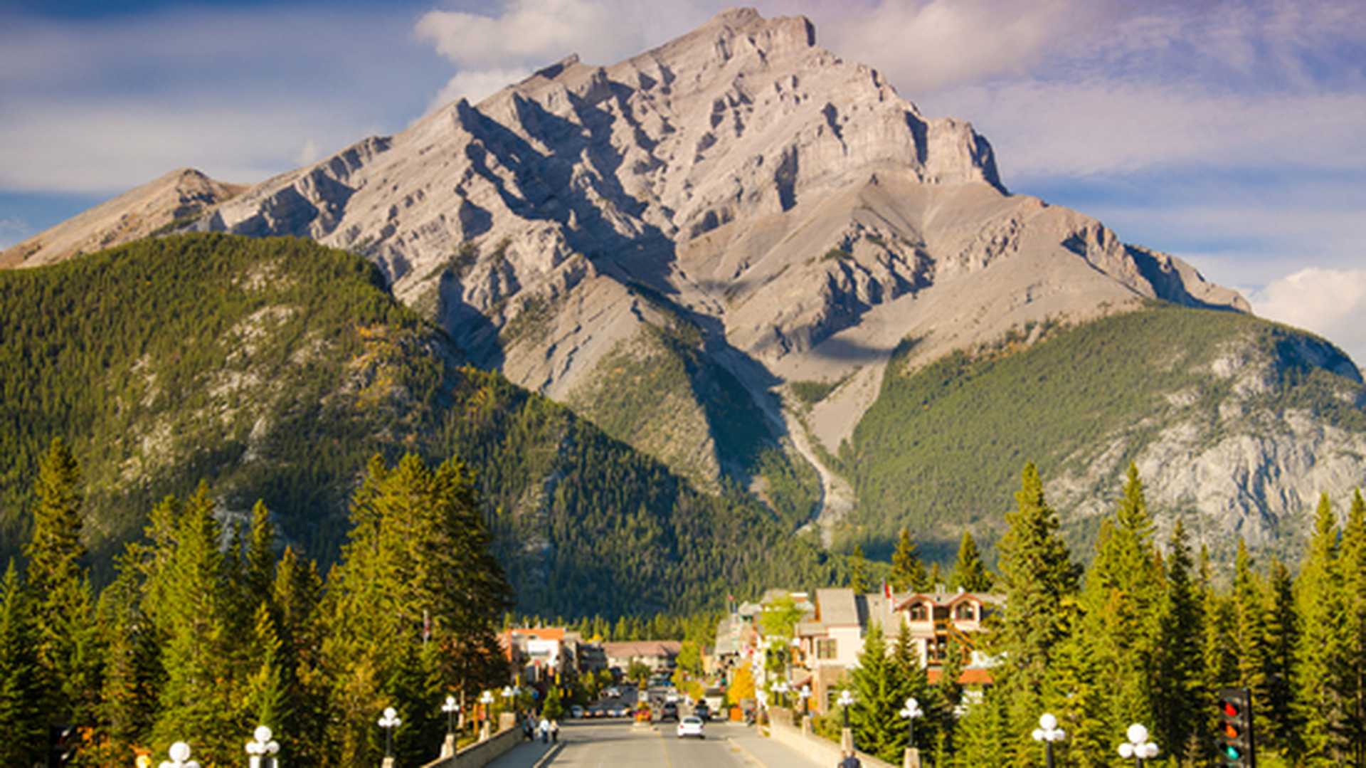 A road leads into the mountain town of Banff, Canada
