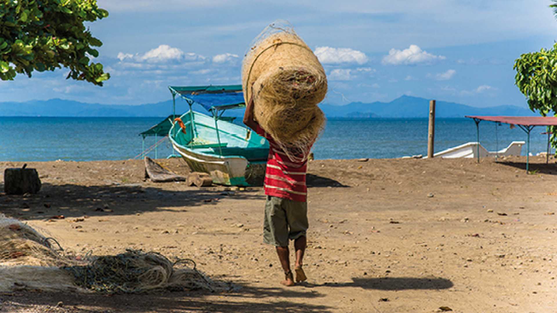 Man carrying fishing net, Tarcoles, Costa Rica. Fishing village