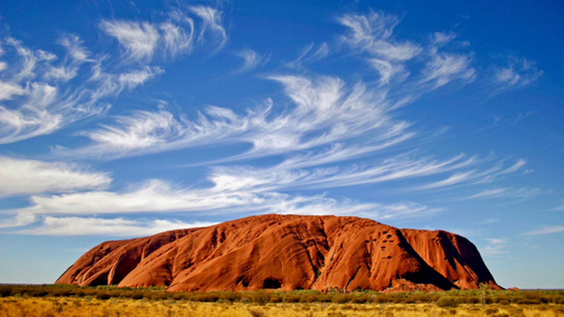 A landscape shot of Uluru, Australia, set against a blue sky