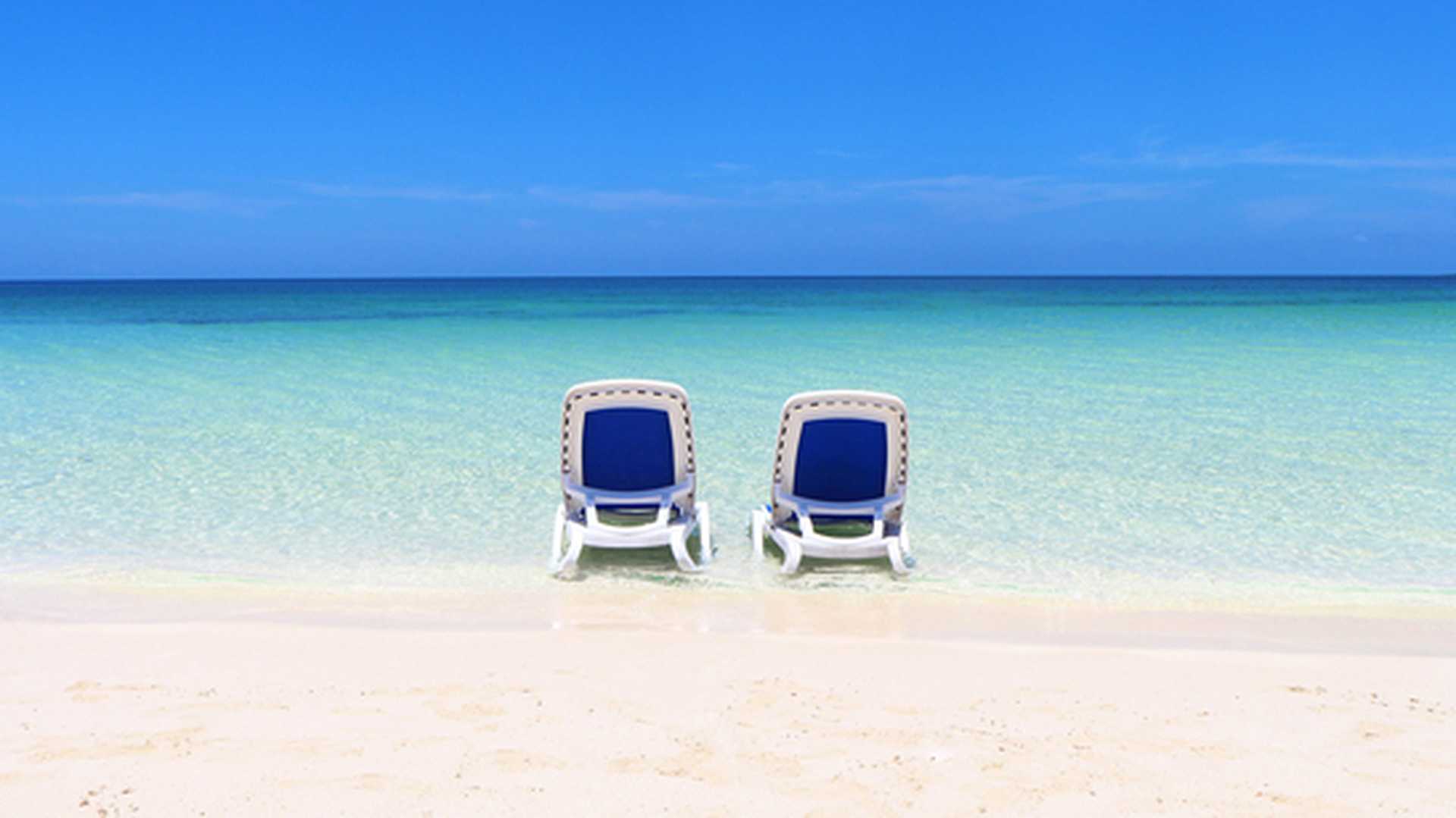 Two loungers are set up in the clear, shallow waters off Cayo Ensenachos's white-sand beach - visited on Titan's Cuba tours