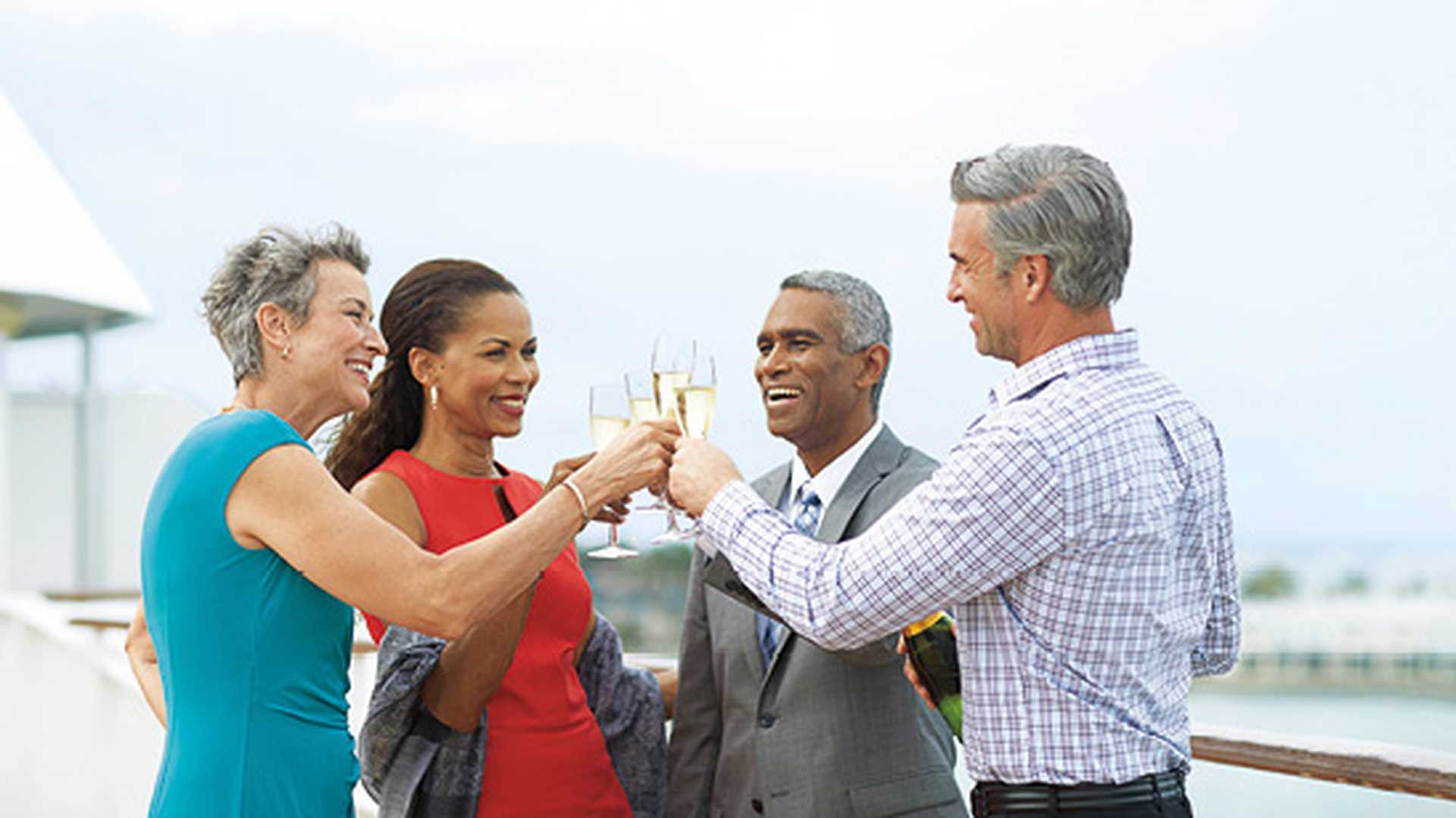 Couples toast champagne on deck of a Holland America Line cruise ship
