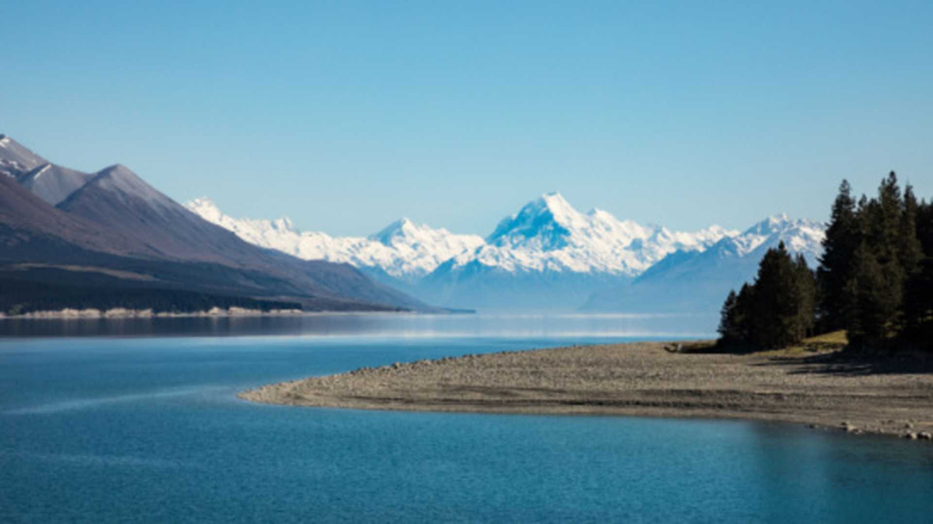 Snow capped Mount Cook set against the blue waters of Lake Taupo, New Zealand