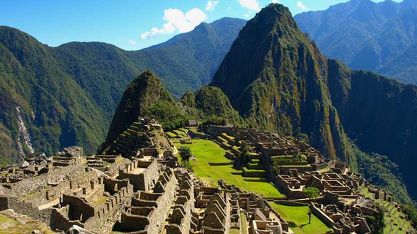 View across the ancient Inca city of Machu Picchu, with forest-cloaked mountains surrounding
