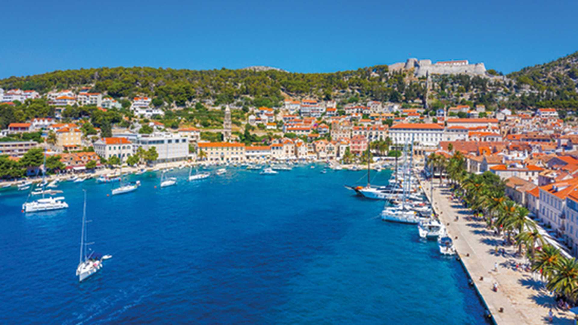 View over blue sea and orange roofed houses of Hvar harbour, Croatia