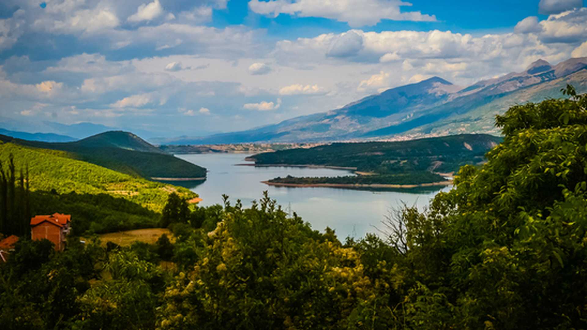 Panoramic view across fields to Debar Lake and hills beyond, a scenic highlight of our Macedonia tours