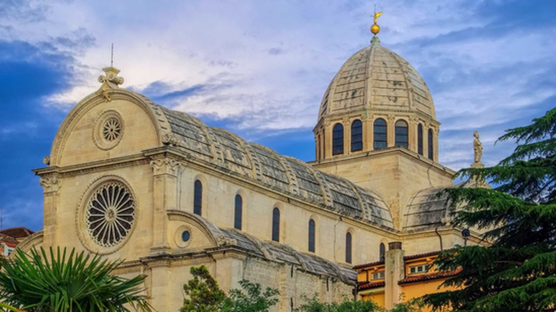 Exterior of Sibenik Cathedral, Croatia, with trees in the foreground