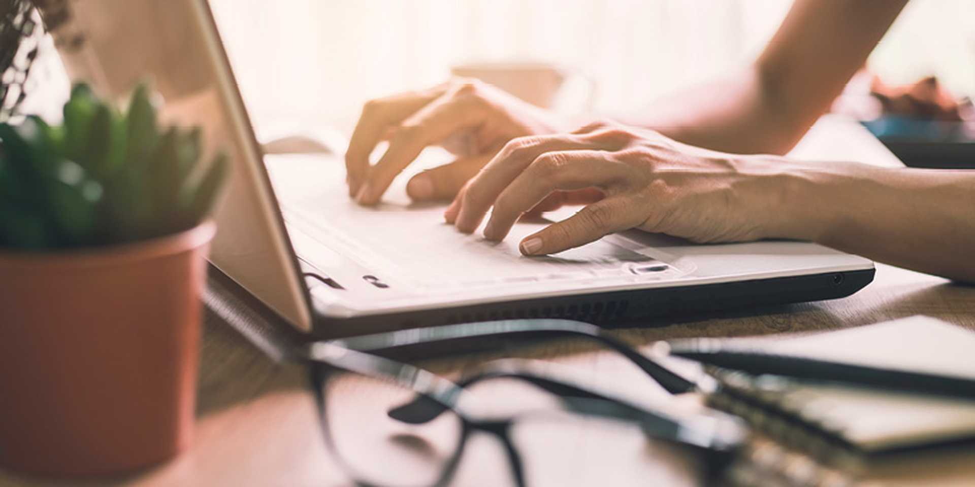 Businesswoman typing on laptop at workplace in home office. 