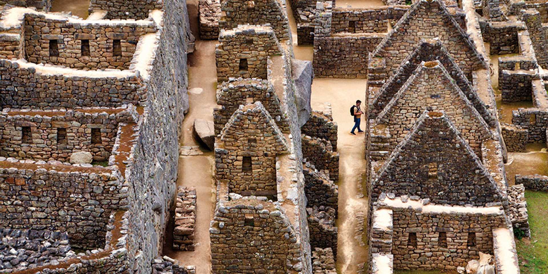 A man wanders through the ruins of the ancient Incan city of Machu Picchu in Peru