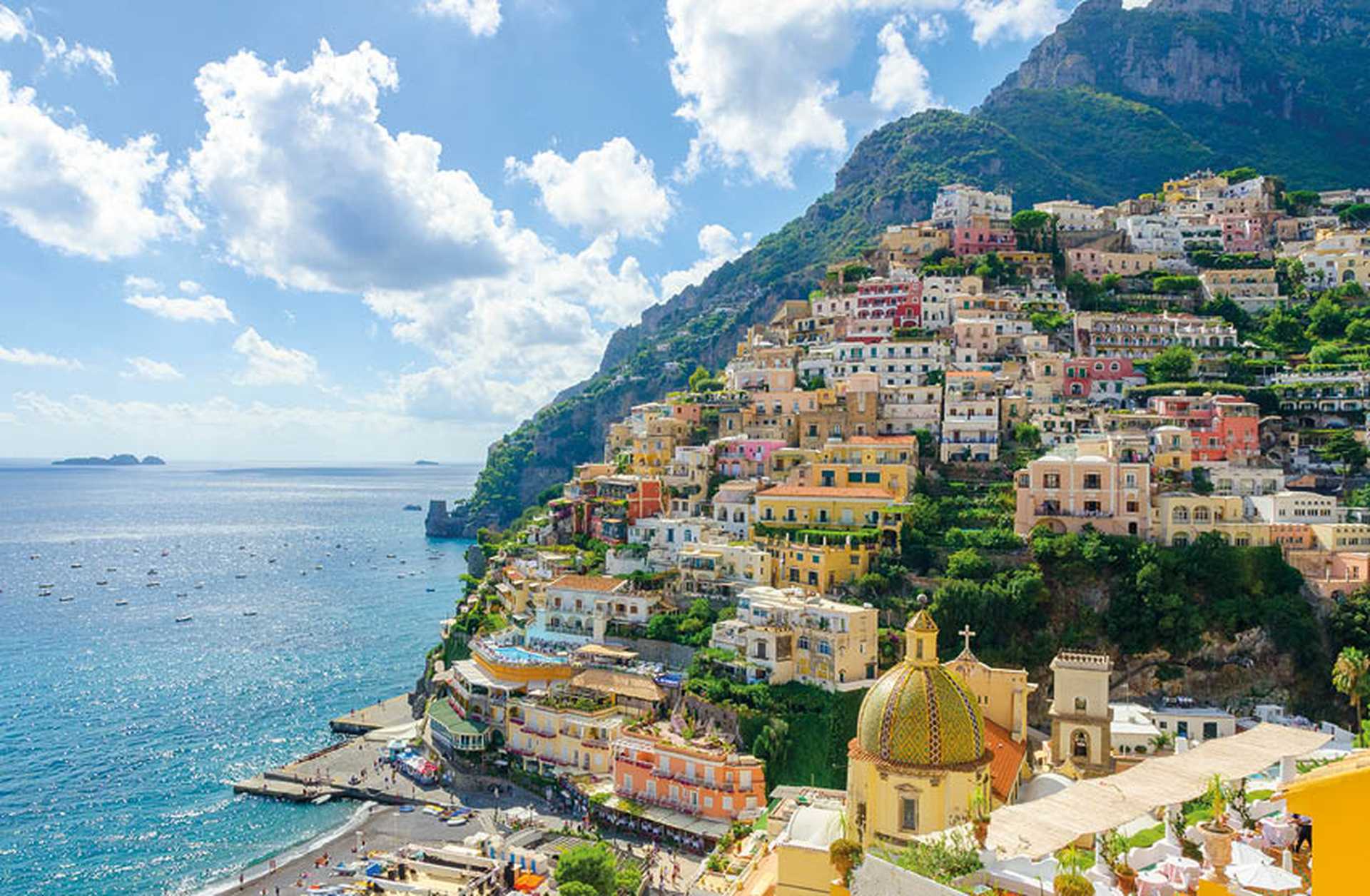 Pastel-coloured houses are built into the cliffside in Positano, Italy