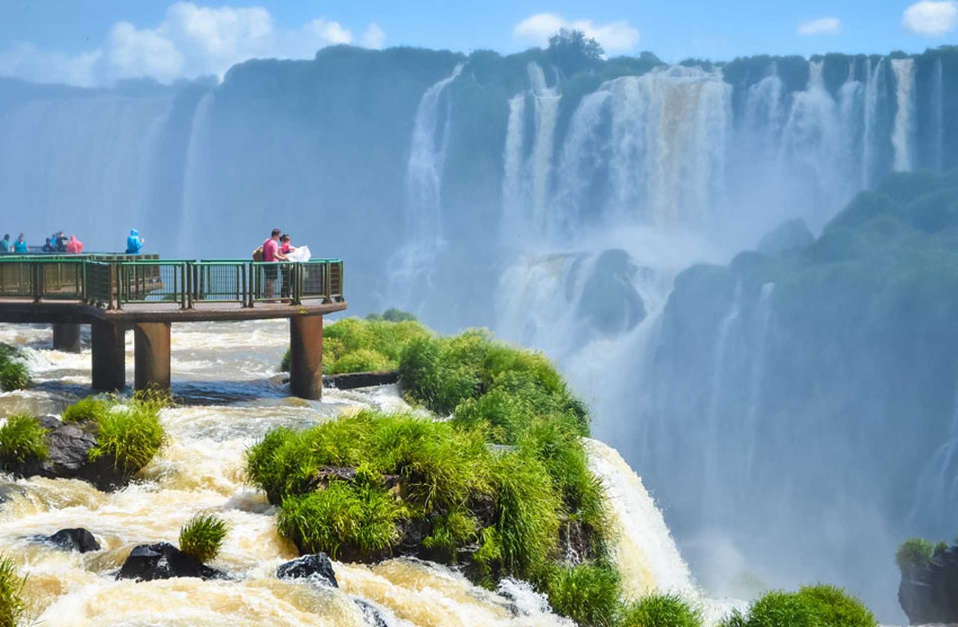 Tourists on wooden footbridges look out across Iguazu Falls on the Brazil/Argentina border