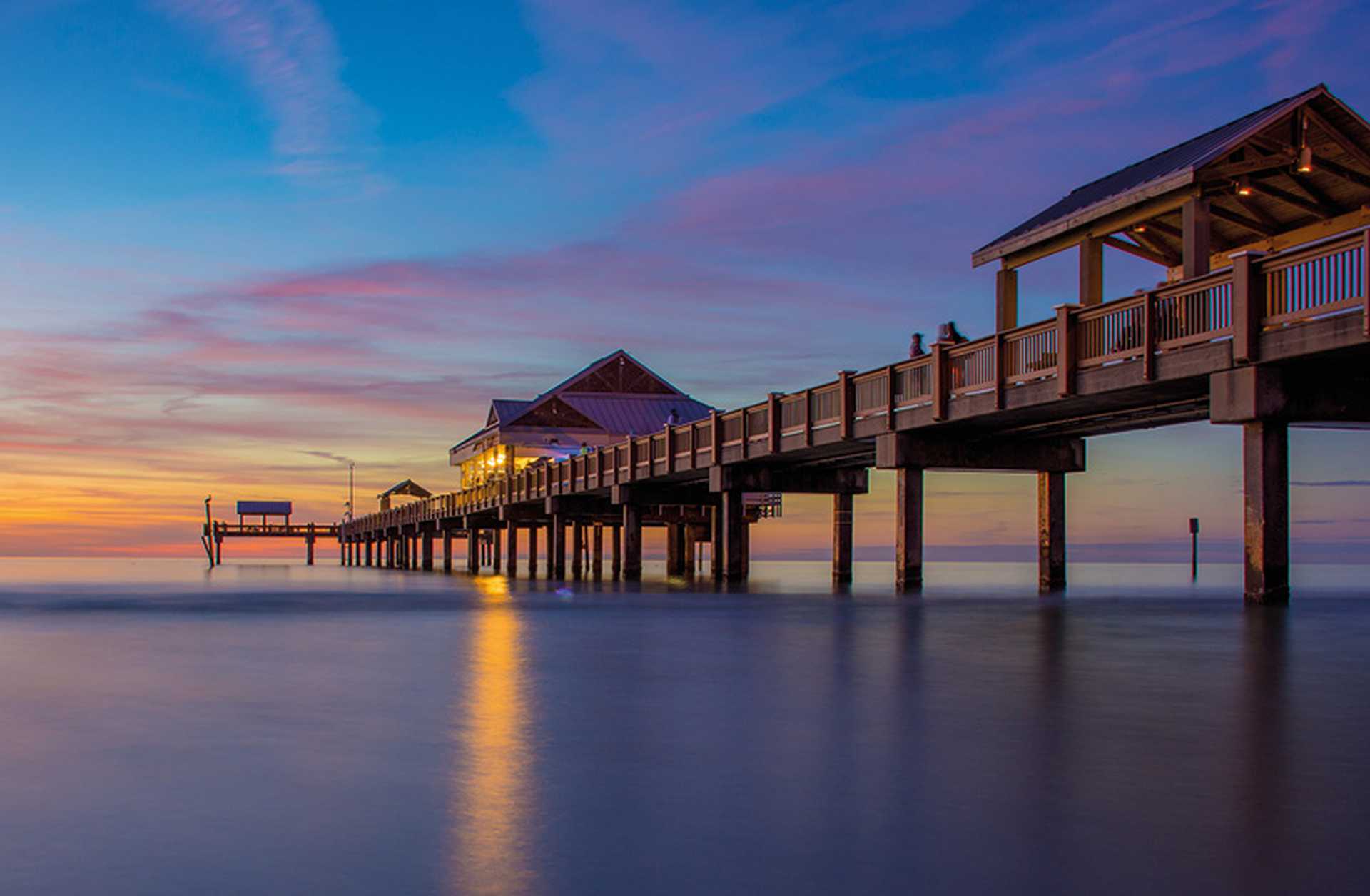 A wooden pier reaches out over the water in Clearwater, Florida