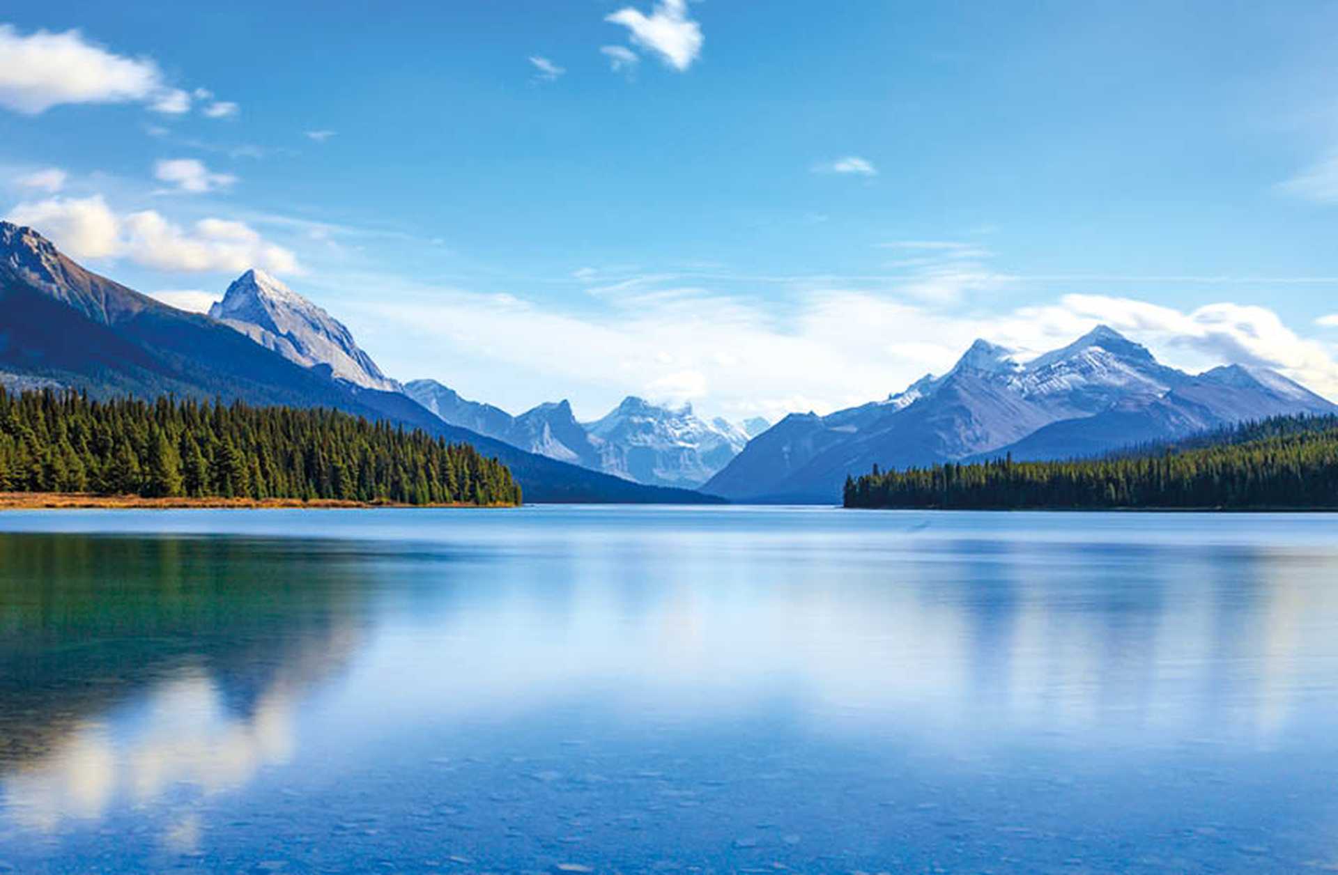 Maligne Lake in Jasper National Park, Canada, with forests and snow-topped mountains in the background